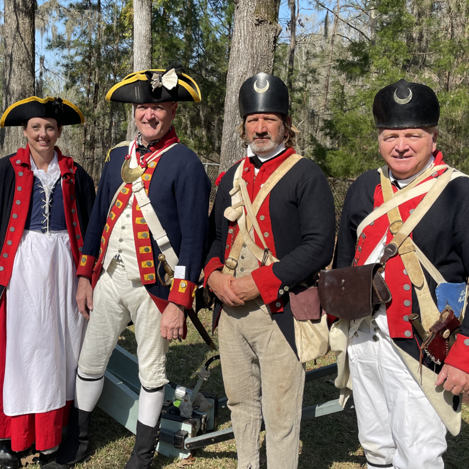 Group of three men and one woman posed as Patriot soldiers at the site of Francis Marion's tomb